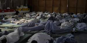 Survivors of a shipwreck sleep at a warehouse at the port in Kalamata,about 240 kilometres southwest of Athens.