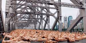 Nude awakening:Thousands flock to Story Bridge for dawn art shoot