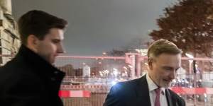 German Finance Minister Christian Lindner,right,gets into his limousine in front of the Reichstag building after his dismissal by Chancellor Olaf Scholz.