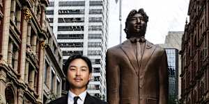 Australian golfer Min Woo Lee standing next to a large statue of himself in Pitt Street Mall.