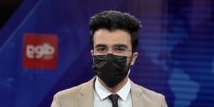 Male newsreaders wear masks in protest as Taliban cover female TV anchors