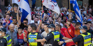 Police contain fans outside Djokovic’s lawyers’ offices in Melbourne on Monday night.