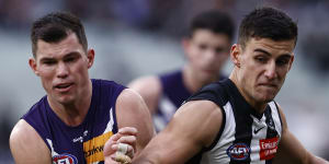 Fremantle’s Jaeger O’Meara tries to bustle Nick Daicos off the ball.