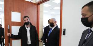 Israeli Prime Minister Benjamin Netanyahu,right,leaves court during his corruption trial.