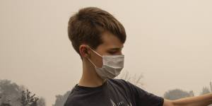 Jacen Sullivan,14,from Talent,Oregon,holds a burned tomato he found in the garden at his burned home.