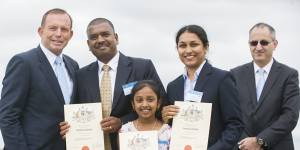 Tony Abbott has his photograph taken in 2015 with a family who took out Australian citizenship after immigrating from India.