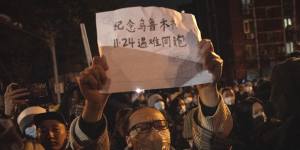 A protester holds up a sign in Beijing on Sunday. 