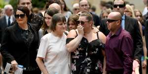 Mourners are seen embracing during a memorial service for White Island volcano victims Anthony,Elizabeth and Winona Langford at Maris College North Shore Auditorium in Sydney.