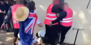 Footage shows crowd safety staff surrounding a man on the ground,before one appears to kick him.