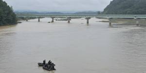 South Korean marines on boats search for missing people in the Sam River in Yecheon.