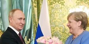 Ostpolitike:Russian President Vladimir Putin,left,presents flowers to then-German Chancellor Angela Merkel during their meeting in the Kremlin in August.