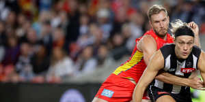 Collingwood’s Darcy Moore locks horns with Gold Coast’s Sam Day.