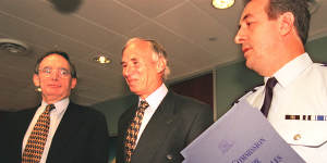 Justice James Wood (centre) hands over his royal commission report into NSW Police to premier Bob Carr in 1997. Police commissioner Peter Ryan holds the report.