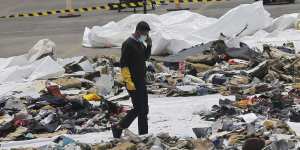 An investigator walks amid debris of Lion Air Flight 610 retrieved from the waters off Tanjung Priok in Jakarta.