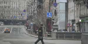 A man wearing the yellow armband of the civil defense crosses a deserted boulevard during an air raid alarm in Kyiv on March 1. 