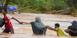 Residents cross a road damaged by El Niño rains in Tula,Tana River county in Kenya.
