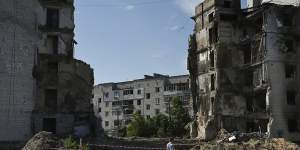 A man walks past the ruins of an apartment building complex destroyed by a Russian missile strike in Borodyanka.