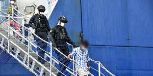 One of the Sri Lankan men is led off the Ocean Shield in Colombo on Friday.