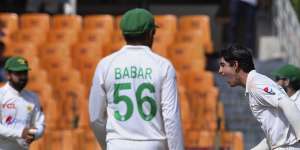 Pakistan’s Naseem Shah,right,celebrates after taking the wicket of Australia’s Nathan Lyon.