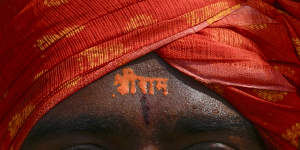 A Hindu devotee has the words Sri Ram’ written on his forehead as he watches in Hyderabad,India,a live telecast of inauguration of a temple. Hindus were encouraged to celebrate the opening of the temple around the world,including in Australia.