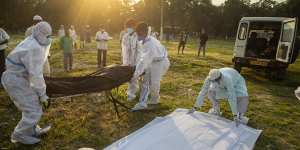 Municipal workers prepare to bury the body of a person who died of COVID-19 in Gauhati,India this week.