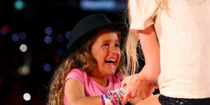 Malina receiving the hat from Swift at the MCG on Friday night.