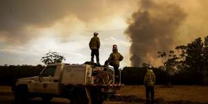 Fire crews work to defend Bombay resident Les Hart's property as the North Black Range bushfire approaches,seen near Bombay,NSW.