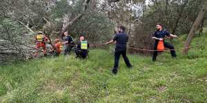 Police and SES crew work to rescue a woman and her dog in Werribee on Boxing Day.