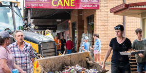 Shop owners try to clean up after floodwaters swept through the town of Molong this week.