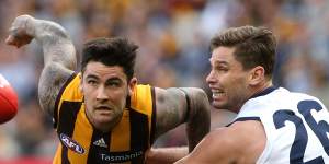 Grab and go:Hawthorn's Chad Wingard attempts to break a tackle by Geelong forward Tom Hawkins.