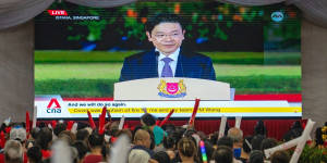 Attendees watch a broadcast of the swearing-in ceremony of Prime Minister Lawrence Wong in Singapore,on Wednesday evening.