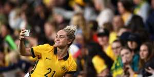 Ellie Carpenter of the Matildas poses with fans after the friendly against Brazil in Sydney last month.