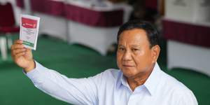 Indonesian presidential candidate Prabowo Subianto shows a ballot during the election in Bojong Koneng,Indonesia.