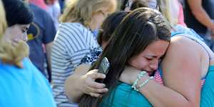 Grim toll:A woman is comforted after the shooting at Umpqua Community College.