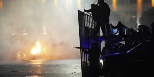 A police car on fire as riot police prepare to stop protesters in the centre of Almaty,Kazakhstan. 