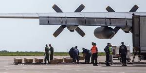 Coffins containing the bodies of victims are loaded onto a plane.