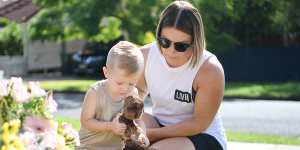 Chantel Taylor and her two year-old son Henley pause after placing teddybears at a makeshift shrine near the scene of the murders.