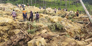 Villagers search landslide debris in the village of Yambali,PNG.