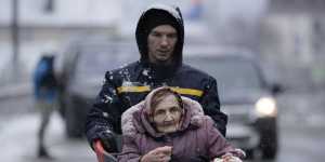 An elderly woman is carried in a shopping cart after being evacuated from Irpin,on the outskirts of Kyiv,Ukraine,on Tuesday.