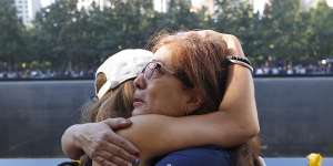 Melinda Moran and Haydee Lillo embrace after finding out they lost people who knew each other,next to the North Reflecting Pool during a ceremony at the National September 11 Memorial&Museum in New York.