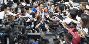 Leader of Move Forward Party Pita Limjaroenrat,rear centre,talks to media after casting his vote during a general election at a polling station in Bangkok.