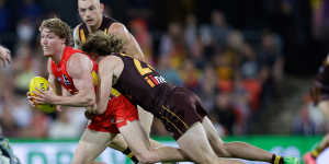 Matt Rowell of the Suns is tackled by Josh Weddle of the Hawks.