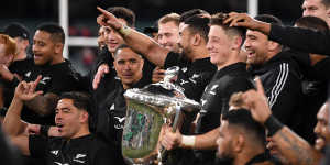 All Blacks players celebrate with the Bledisloe Cup.