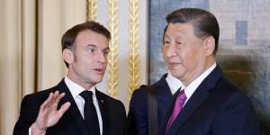 French President Emmanuel Macron talks with Chinese President Xi Jinping during a state dinner at the Elysee Palace in Paris on Monday.