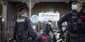 A bloodied anti-lockdown protester is detained by police after a scuffle on Victoria Street in North Melbourne.