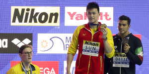 China's Sun Yang,centre,with his gold medal as silver medallist Australia's Mack Horton,left,stands away from the podium.