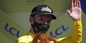 Adam Yates wearing a mask and the coveted yellow jersey.