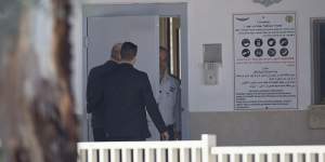 Ehud Olmert,left,enters prison to begin his sentence in the central Israeli town of Ramle.
