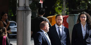 Timothy Malcolm Rowland (centre) arrives at Downing Centre District Court with his lawyers.