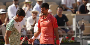 Novak Djokovic,right,accompanies Spain’s Carlos Alcaraz after he suffered leg cramps during their semifinal match of the French Open.